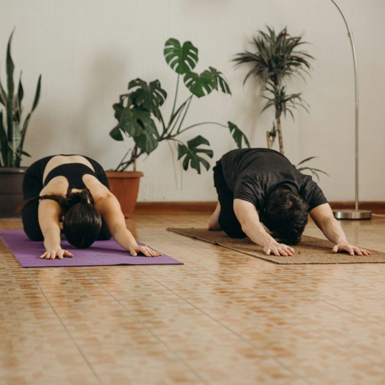 Yin Yoga - Fortbildung Zwei Personen machen Yoga in einer ruhigen Umgebung mit Pflanzen im Hintergrund.